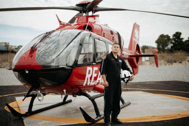 Medical student-paramedic stands next to helicopter.