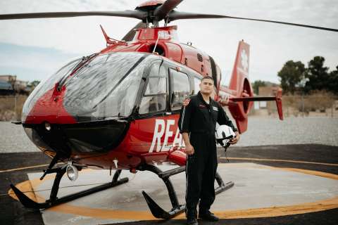 Medical student-paramedic stands next to helicopter.