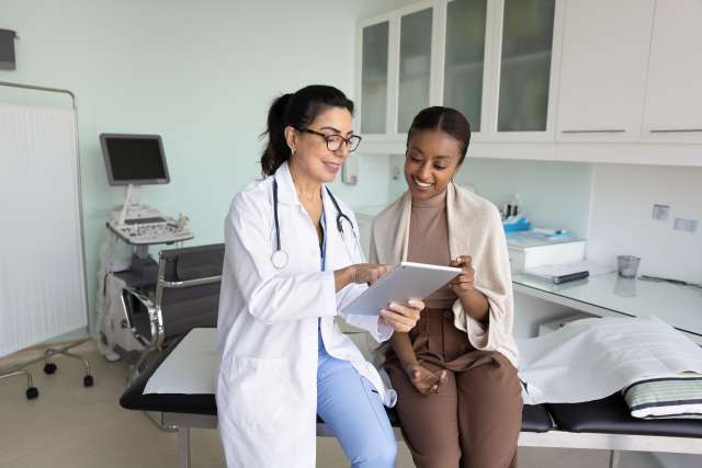 Female doctor showing a patient information on a tablet during a visit